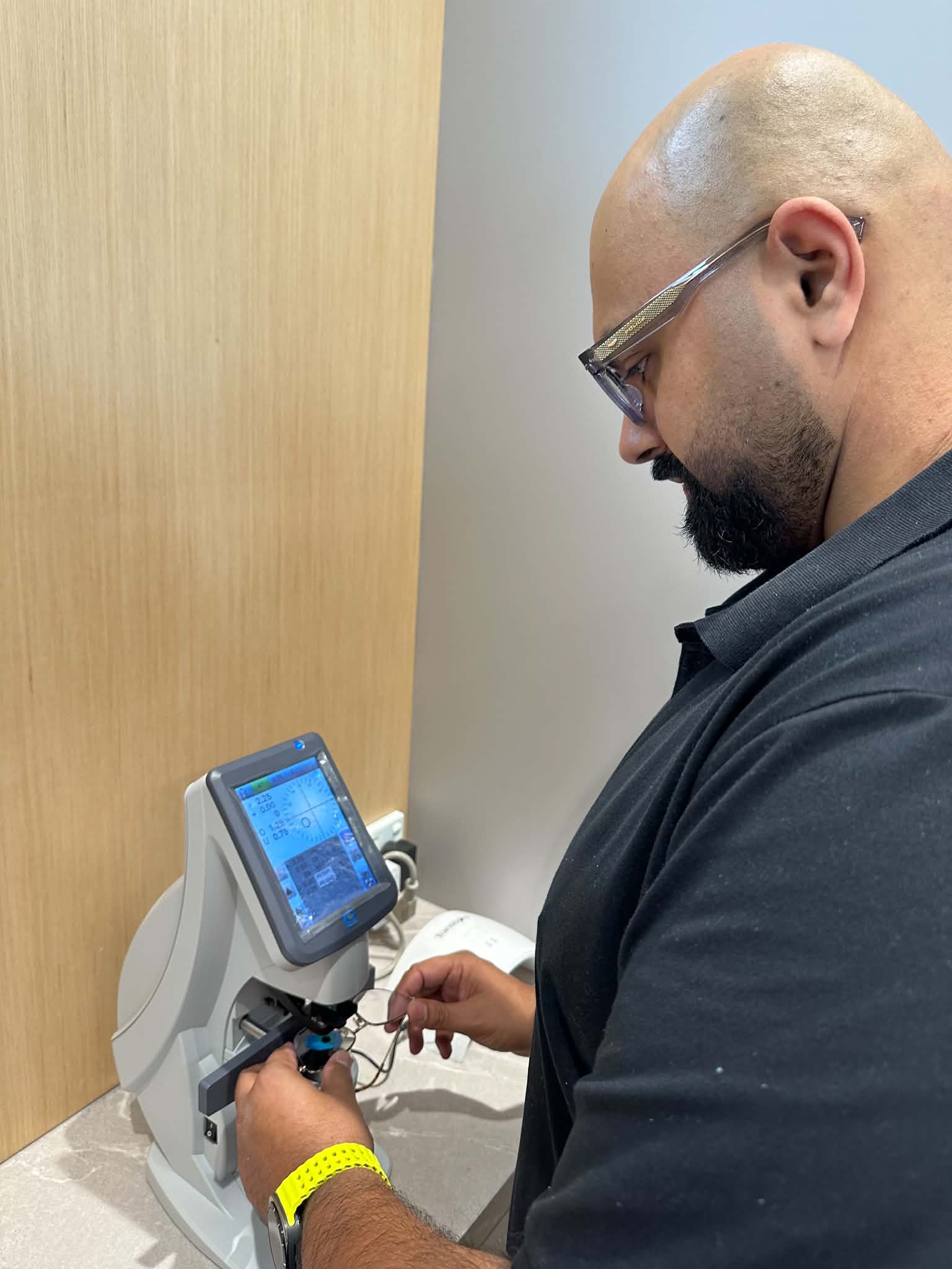 Optical team member checking glasses before lens replacement