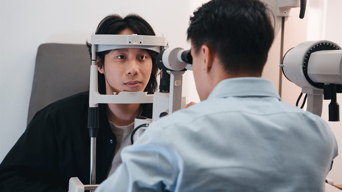 City Optics optometry team member examining a patient with clinical eye testing equipment
